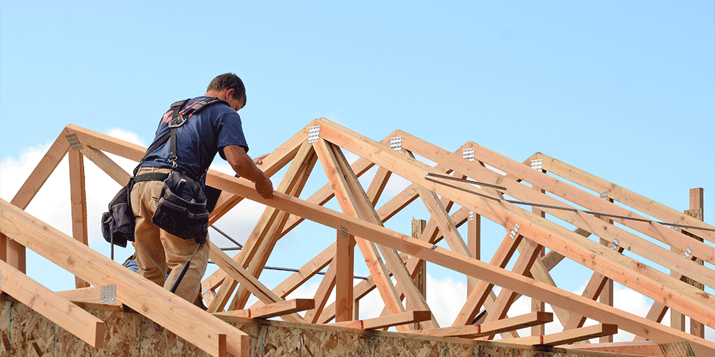 Construction worker working on creating the ceiling of a Demlang home outside