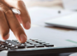 accountant working on desk using calculator for calculate finance report in office