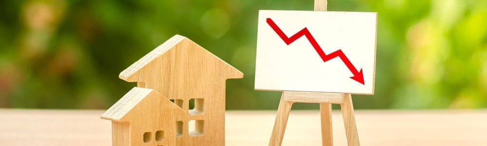 Wooden houses and an easel red arrow down. The fall of the real estate market. concept of value or cost decrease. low liquidity and attractiveness. cheap rent. Reduced demand and stagnation. Wooden houses and an easel red arrow down. The fall of the real estate market. concept of value or cost decrease. low liquidity and attractiveness. cheap rent. Reduced demand and stagnation.