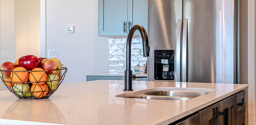 Kitchen island with black curved faucet and stainless steel double bowl sink