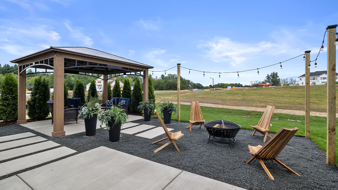 Parade of Homes model, The Lexi, backyard entertaining space featuring a fire place and sitting furniture under a gazebo