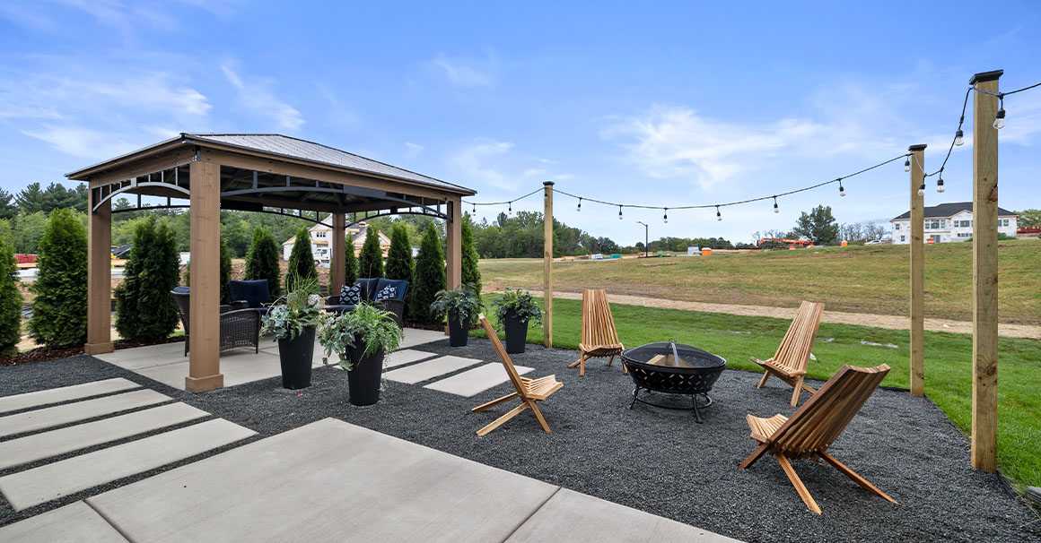 Parade of Homes model, The Lexi, backyard entertaining space featuring a fire place and sitting furniture under a gazebo