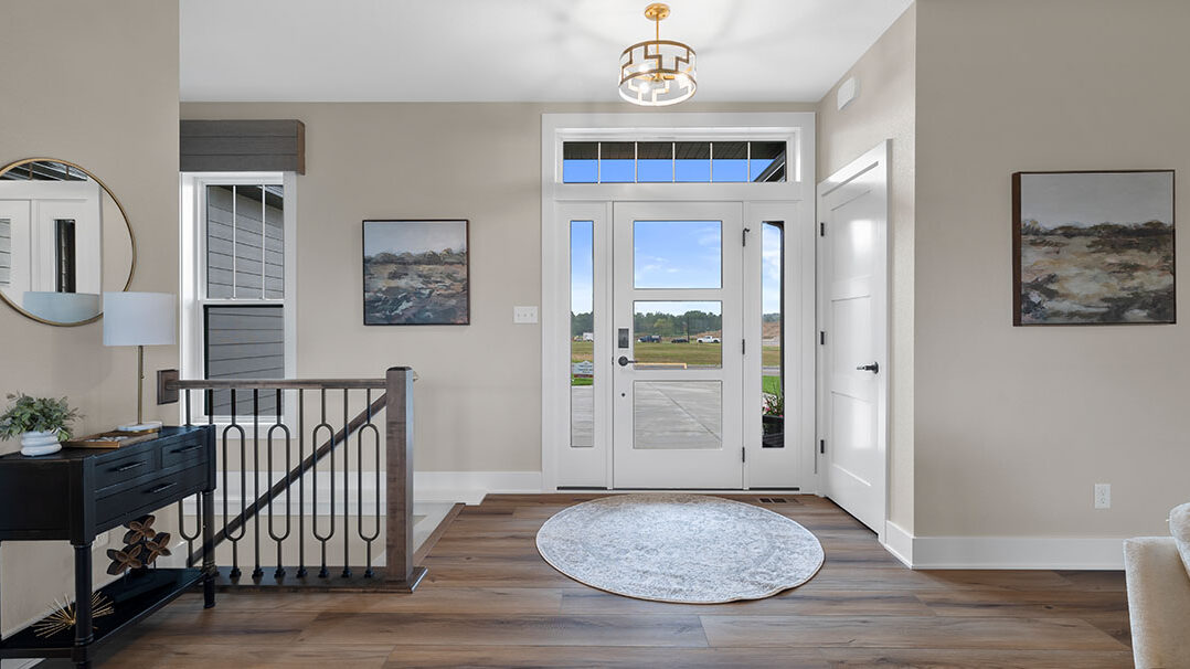 Parade of Homes model, The Lexi, front foyer with large rug and open glass front door