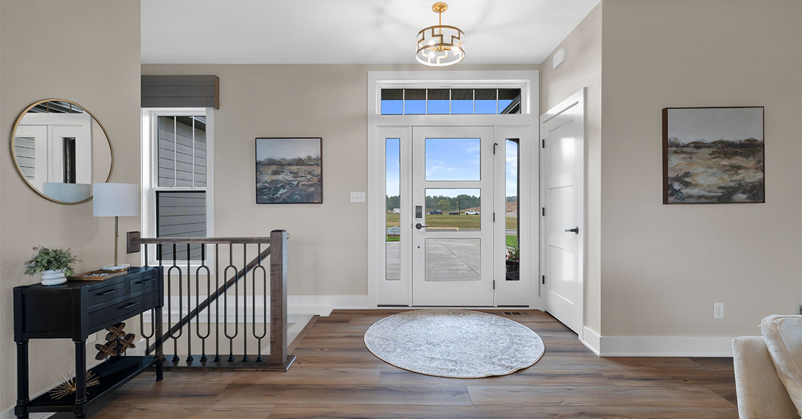 Parade of Homes model, The Lexi, front foyer with large rug and open glass front door