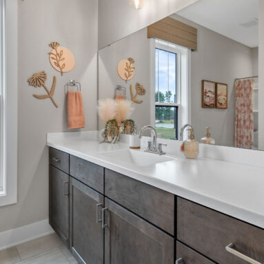 Parade of Homes model, The Lexi, secondary full bathroom features bright white counters with contrasting dark wood lowers.