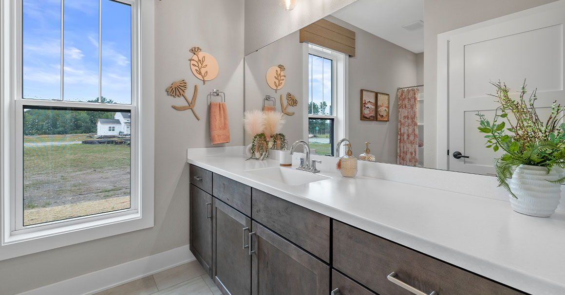 Parade of Homes model, The Lexi, secondary full bathroom features bright white counters with contrasting dark wood lowers.