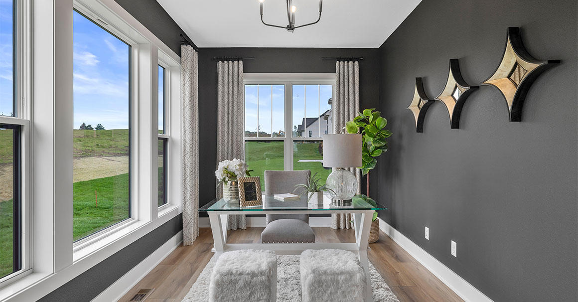 Parade of Homes model, The Lexi, flex room that is staged as an at home office. This room features dark walls with constrating white trim.